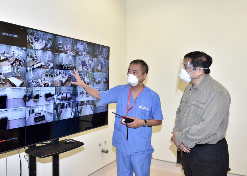 Thủ tướng Phạm Minh Chính và Giám đốc Bệnh viện Đại học Y Hà Nội Nguyễn Lân Hiếu theo dõi hệ thống giám sát trung tâm tại Bệnh viện dã chiến Hồi sức cấp cứu Bình Dương - Ảnh: VGP