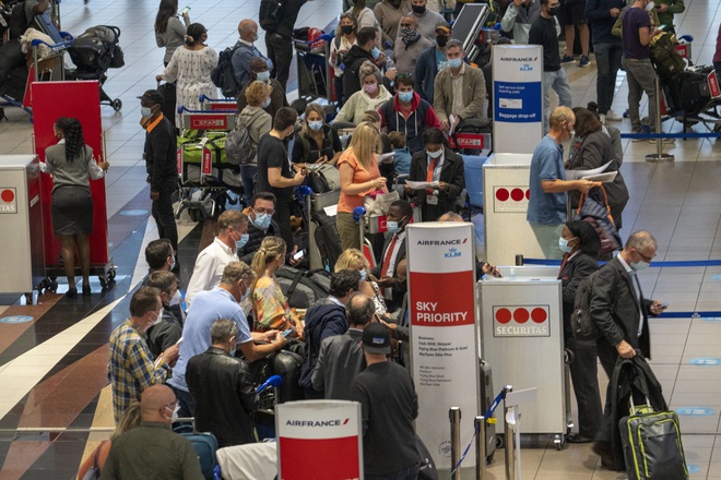 Hành khách xếp hàng tại sân bay Johannesburg để rời Nam Phi sau tin tức về Omicron - Ảnh: AP