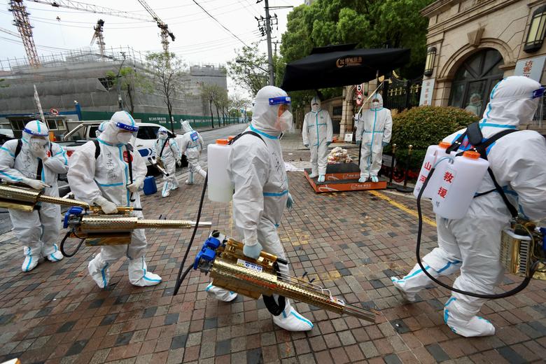 Những nhân viên trong trang phục bảo hộ đang chuẩn bị phun khử khuẩn một khu dân cư ở quận Hoàng phố để hạn chế sự lây lan COVID-19 ở Thượng Hải. Ảnh: Reuters