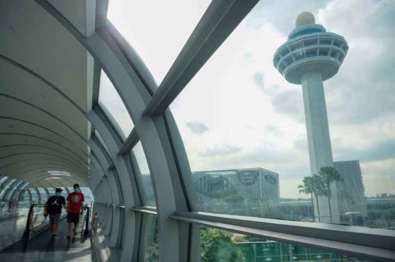 Khách du lịch đang đi bộ tại sân bay quốc tế Changi, Singapore vào tháng 11/2021 - Ảnh: AFP
