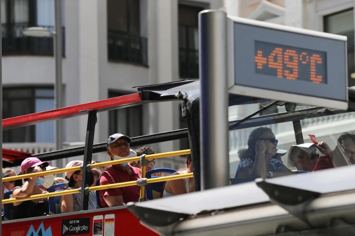 Một xe bus chở khách du lịch đi ngang qua biển thông báo nhiệt độ ngoài trời ở mức 49 độ C tại Gran Via trong đợt nắng nóng kỷ lục ở Madrid, Tây Ban Nha - Ảnh: Reuters