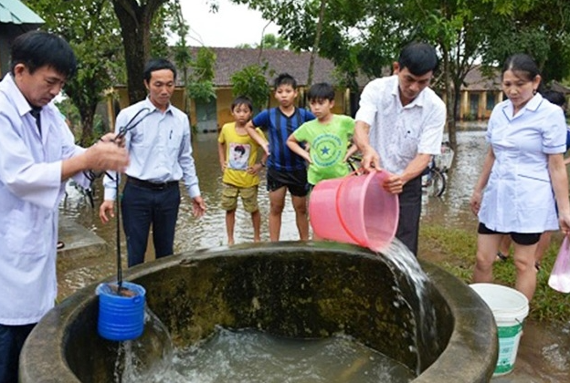 Dùng hóa chất để khử trùng nước ăn uống và sinh hoạt theo hướng dẫn của nhân viên y tế - Ảnh: baochinhphu.vn
