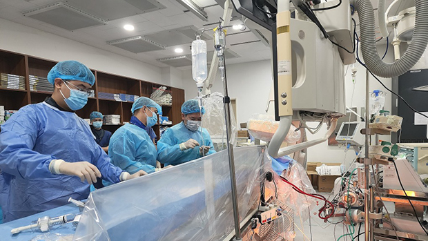 Các bác sỹ can thiệp tim mạch khi bệnh nhân vẫn tỉnh táo nhờ hỗ trợ của ECMO - Ảnh: Quang Minh