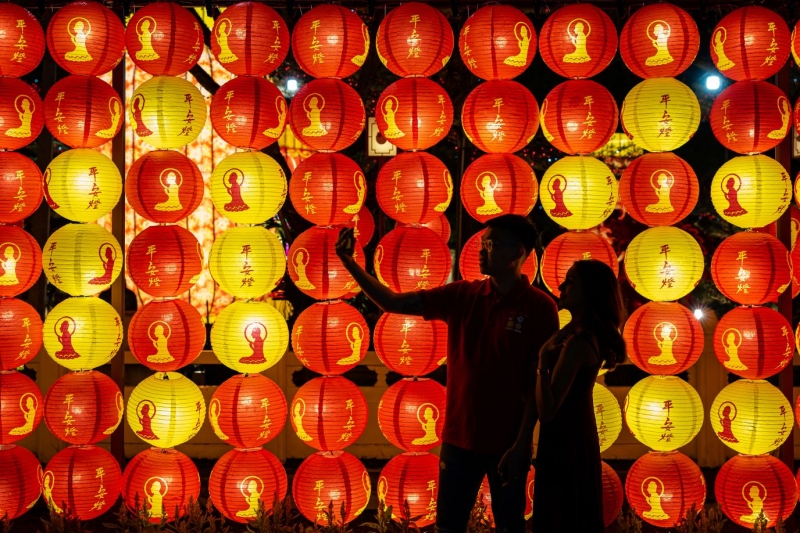 Một cặp đôi đang lưu lại thời khắc thiêng liêng của đêm giao thừa trước đèn lồng trang trí tại Phật Quang Sơn Đông Thiền tự ở Malaysia. Ảnh: Getty Images