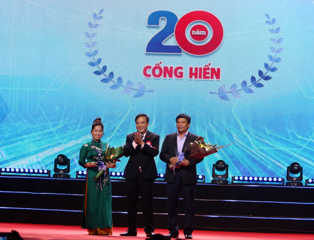Bà Vũ Thị Thu Hà và ông Chu Phúc Chiếm nhận hoa và kỷ niệm chương từ Chủ tịch Nguyễn Xuân Hoàng  