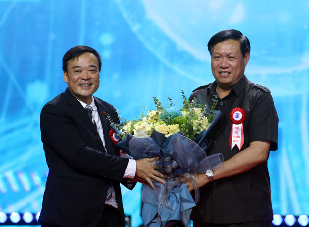 Thứ trưởng Bộ Y tế Đỗ Xuân Tuyên nhận bó hoa tươi thắm từ Chủ tịch HĐTV Nguyễn Xuân Hoàng 