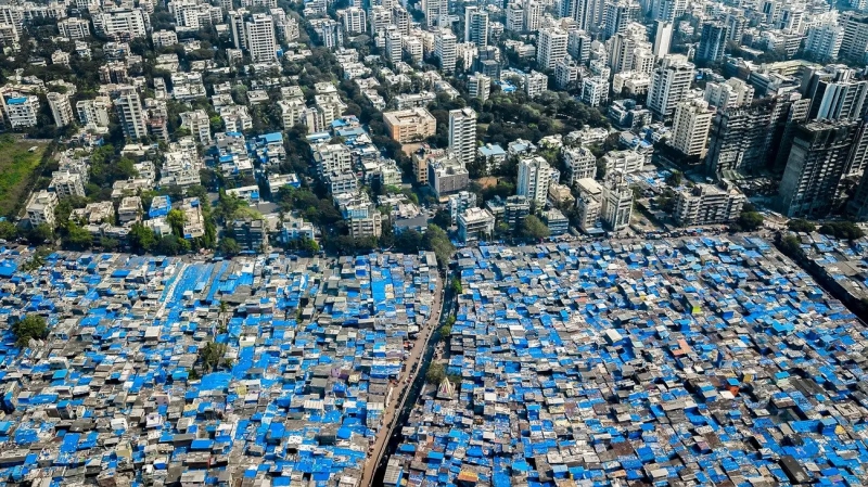 Ranh giới giàu nghèo tại Mumbai (Ấn Độ), với khu ổ chuột Dharavi toàn những ngôi nhà mái xanh - Ảnh: Nhiếp ảnh gia Johnny Miller/Insider
