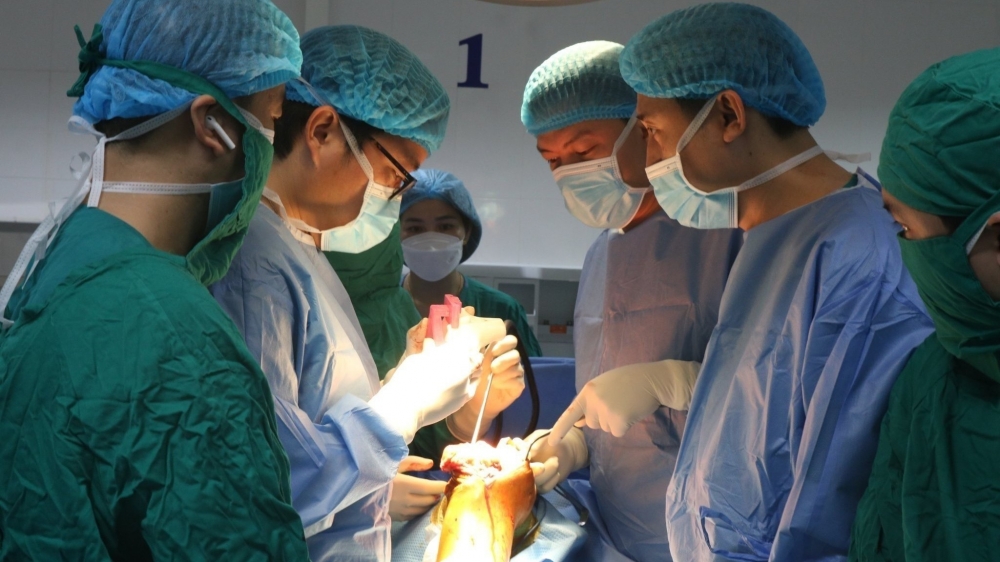 GS.TS Trần Trung Dũng (người đeo kính) cùng các bác sĩ BVĐK tỉnh phẫu thuật thay khớp gối toàn phần (công nghệ in 3D) cho bệnh nhân Nguyễn Thị Thanh