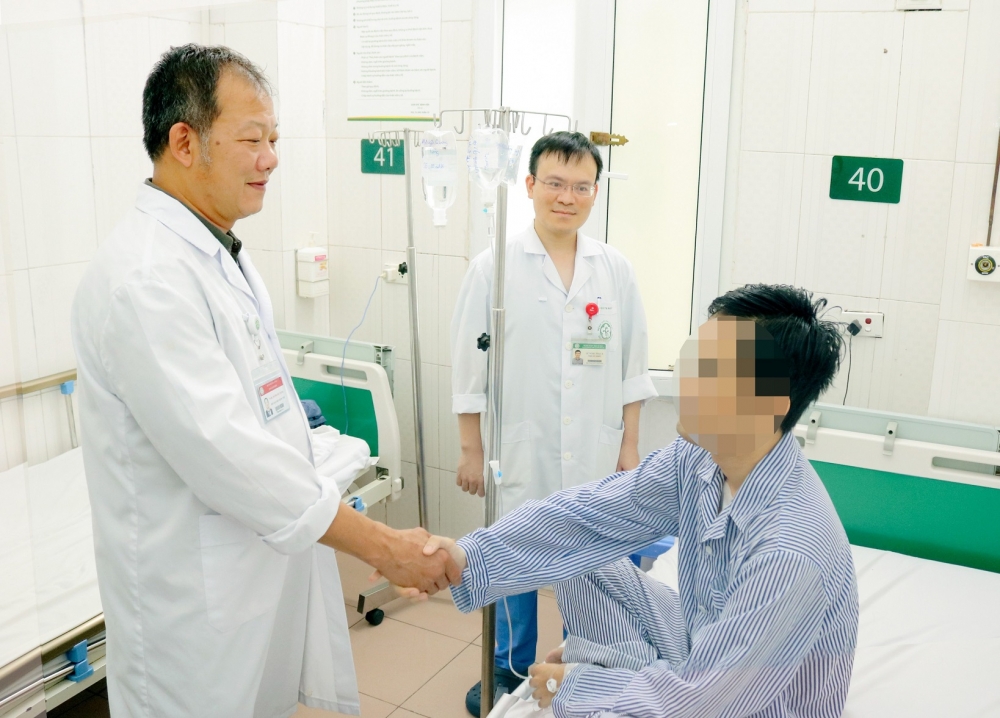 TS.BS Dương Đức Hùng chúc mừng bệnh nhân đã thoát khỏi cửa tử - Ảnh: BVCC