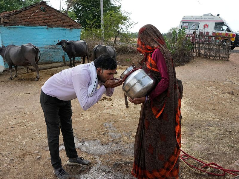 Theo AP, vào tháng 6 vừa qua, tại Ấn Độ, sóng nhiệt khắc nghiệt đã khiến hàng trăm người thiệt mạng ở một số khu vực nghèo nhất của quốc gia này. Trong ảnh: Một người phụ nữ đưa nước cho tài xế uống để làm dịu cơn khát trong ngày Hè nóng nực ở bang Uttar Pradesh, Ấn Độ - Ảnh: AP.