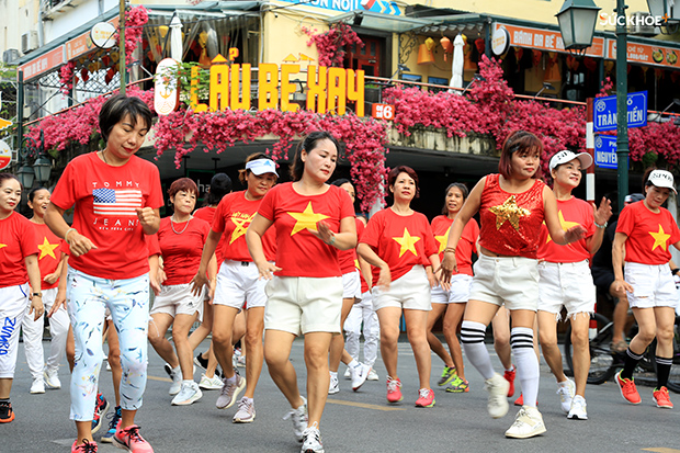 Một nhóm cư dân phường Tràng Tiền mặc áo cờ Tổ Quốc nhảy đồng diễn trên phố Tràng Tiền