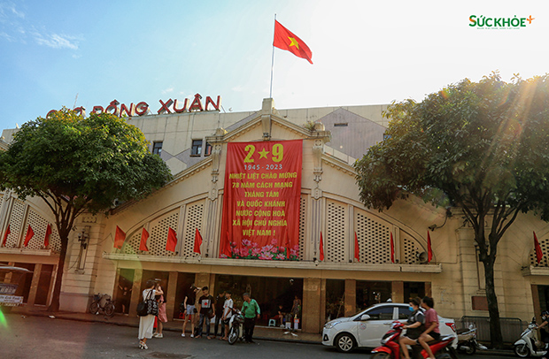 Biểu ngữ chào mừng Quốc khánh 2/9 và cờ đỏ sao vàng tung bay tại chợ Đồng Xuân