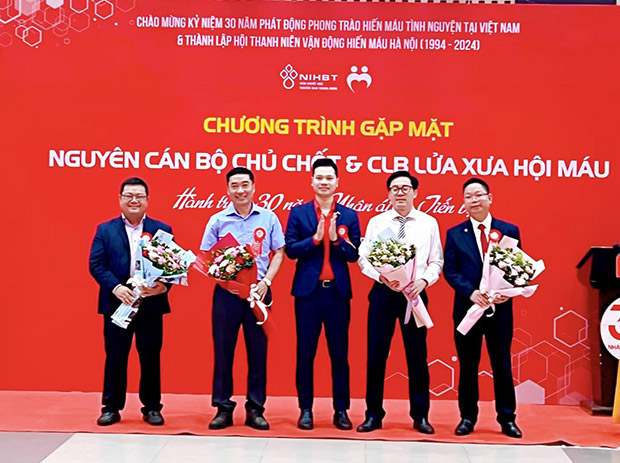 Ông Trịnh Xuân Thủy, Chủ tịch Hội Thanh niên vận động hiến máu Hà Nội, tặng hoa cho các nguyên cán bộ chủ chốt của Hội - Ảnh: facebook hoimauhanoi
