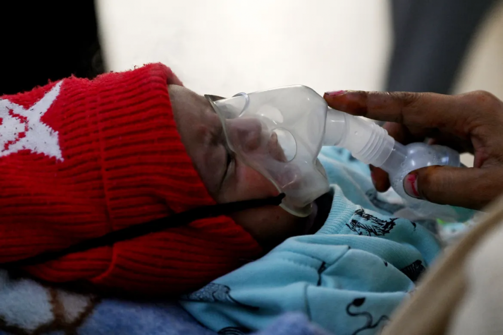 Với chiếc máy phun khí dung trên khuôn mặt nhỏ xíu, bé Ayansh Tiwari, một tháng tuổi, bị ho liên tục. Các bác sĩ cho rằng nguyên nhân là do không khí ô nhiễm tàn phá New Delhi hàng năm - Ảnh: Arun Sankar/AFP