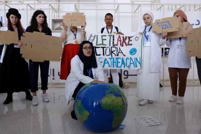 Các thành viên của Liên đoàn Sinh viên Y khoa Quốc tế cầm biểu ngữ trong cuộc biểu tình yêu cầu chấm dứt nhiên liệu hóa thạch tại Hội nghị COP28, ngày 3/12/2023 - Ảnh: REUTERS