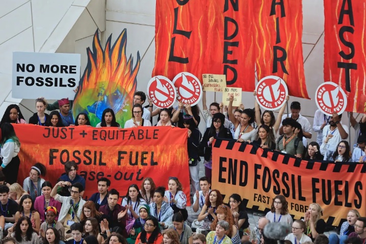 Các nhà hoạt động khí hậu mang biểu ngữ phản đối nhiên liệu hóa thạch trong giai đoạn cuối của Hội nghị COP28 ở Dubai - Ảnh: Reuters