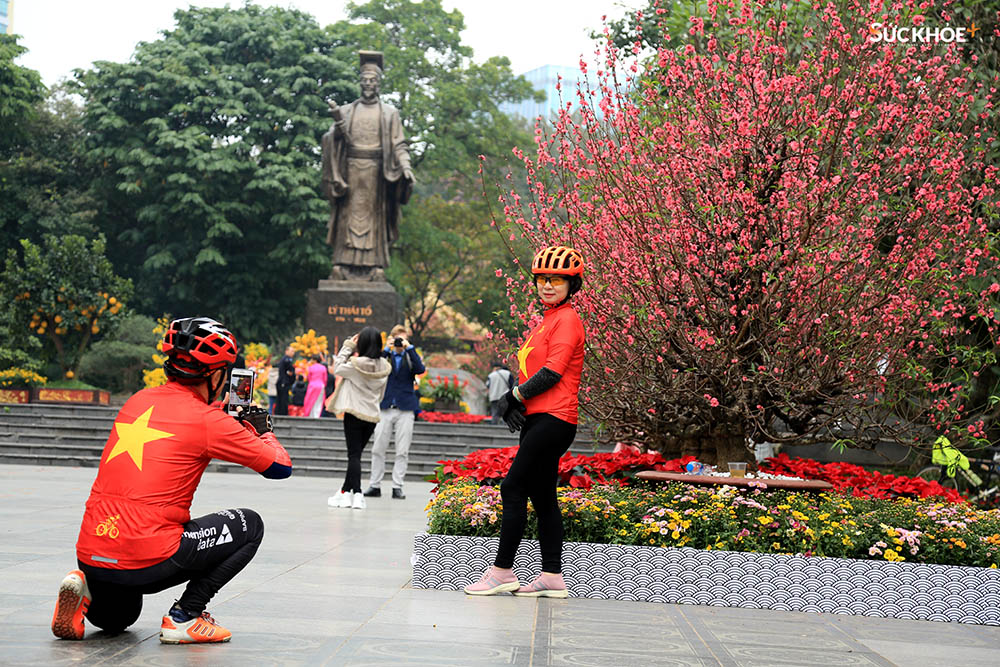 Một cặp vợ chồng trong trang phục cờ đỏ sao vàng chụp ảnh lưu niệm trước khu vực tượng đài Lý Thái Tổ sáng mùng 1 Tết