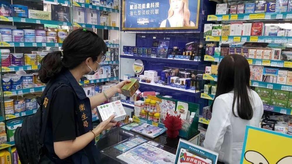 Cơ quan y tế của chính quyền thành phố ở Kahosiung đang kiểm tra các sản phẩm của Kobayashi tại một hiệu thuốc ở Đài Loan - Ảnh: Kyodo