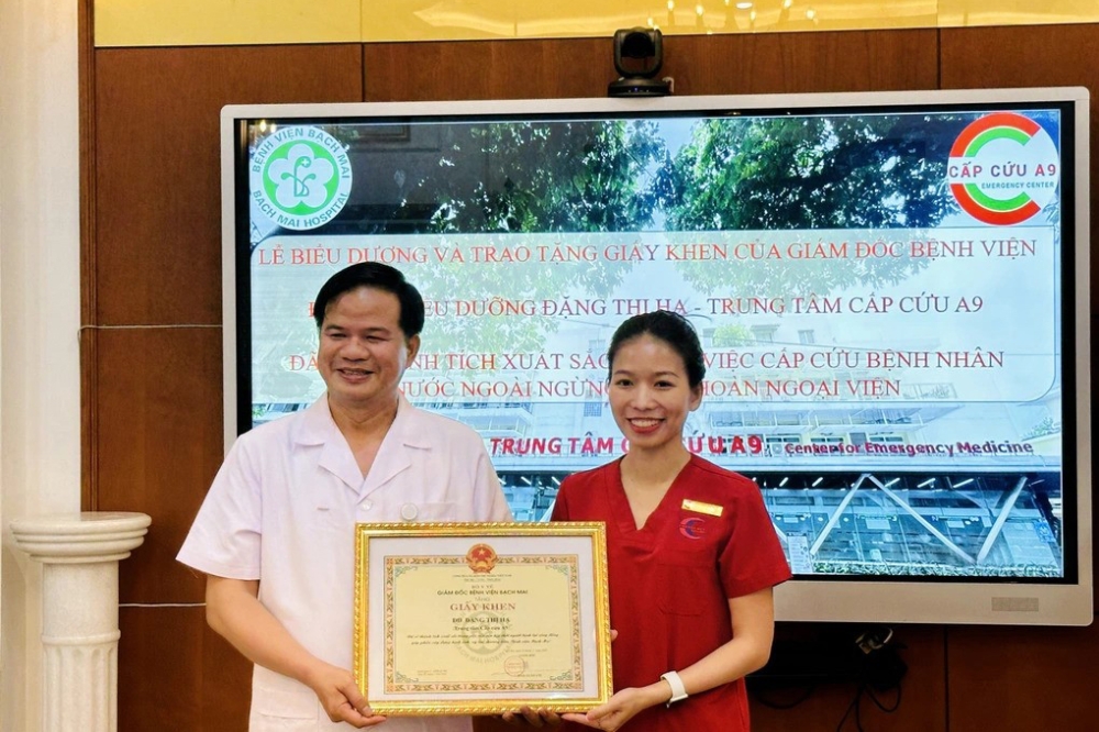 PGS.TS Đào Xuân Cơ - Giám đốc Bệnh viện Bạch Mai trao bằng khen tới điều dưỡng Đặng Thị Hạ - Ảnh: Dân Trí