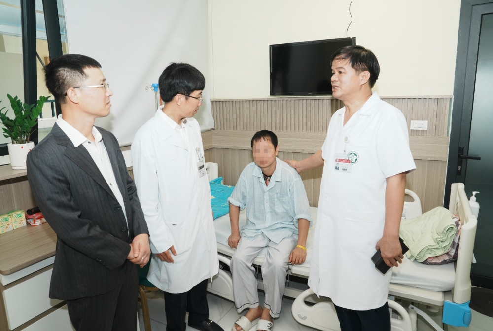 PGS.TS Đào Xuân Cơ (bên phải), PGS.TS Mai Duy Tôn cùng nhà tài trợ thăm bệnh nhân đang điều trị tại Trung tâm đột quỵ, Bệnh viện Bạch Mai - Ảnh: Thành Dương
