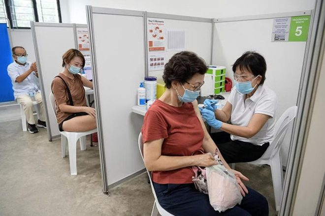 Người dân Singapore được tiêm vaccine COVID-19 tại một trạm y tế - Ảnh: Straits Times