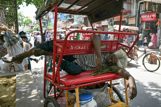 Một người đàn ông kéo xe đang nghỉ trưa ngoài trời trên đường phố ở New Delhi, Ấn Độ, giữa đợt nắng nóng chết người vào ngày 31/5 - Ảnh: AFP/Getty Images