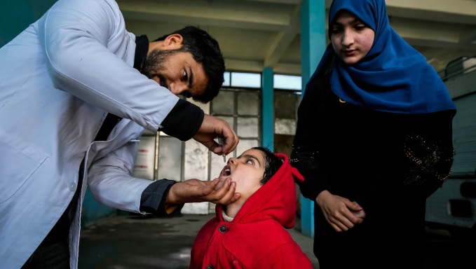 Một nhân viên y tế đang cho trẻ uống vaccine ngừa bại liệt ở Srinagar, Kashmir, Ấn Độ - Ảnh: Mukhtar Khan/AP