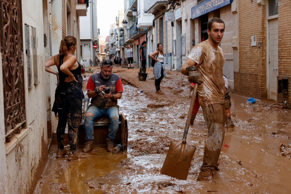 Người dân đang dọn dẹp sau trận lũ quét ở Paiporta, gần Valencia, Tây Ban Nha, ngày 1/11 - Ảnh: Reuters