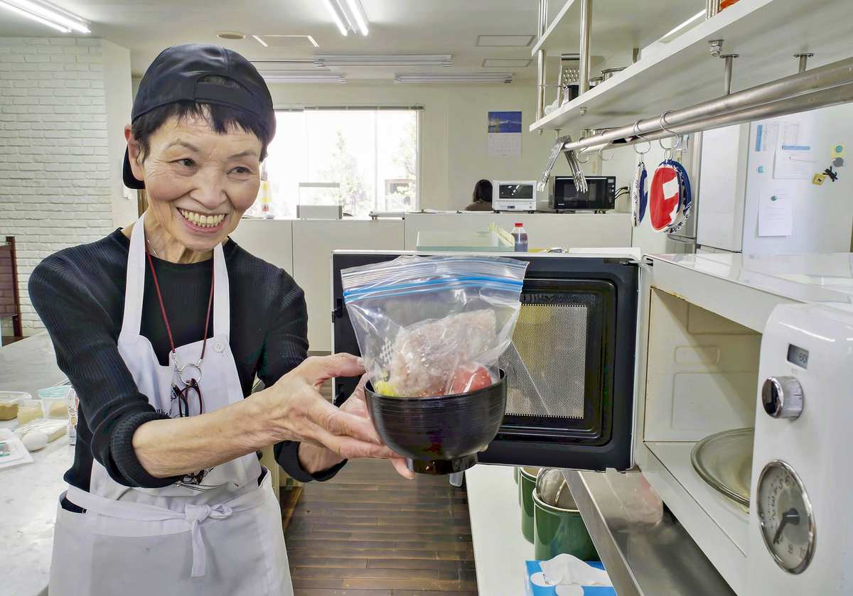 Bà Sachiko Murakami, 83 tuổi, chia sẻ cách chuẩn bị bữa ăn nhanh gọn với lò vi sóng - Ảnh: Tờ Yomiuri Shimbun