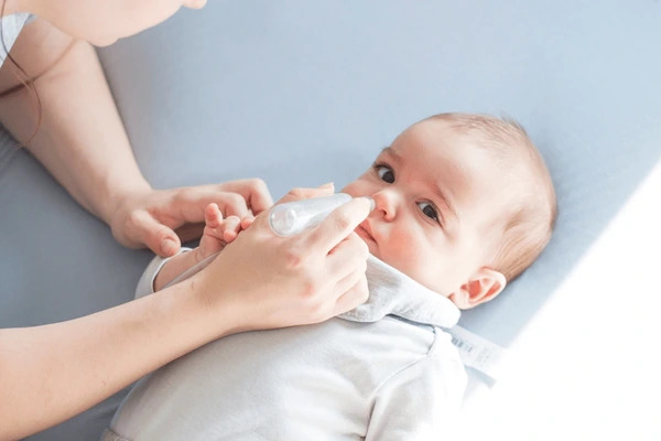 Vệ sinh mũi cho trẻ bằng dụng cụ hút mũi hoặc nước muối sinh lý