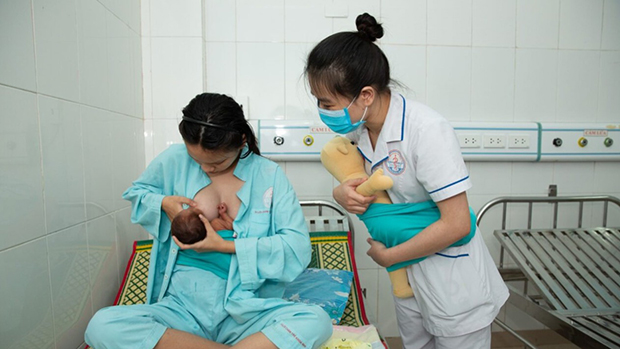 Nhân viên y tế hướng dẫn mẹ cho con bú đúng cách