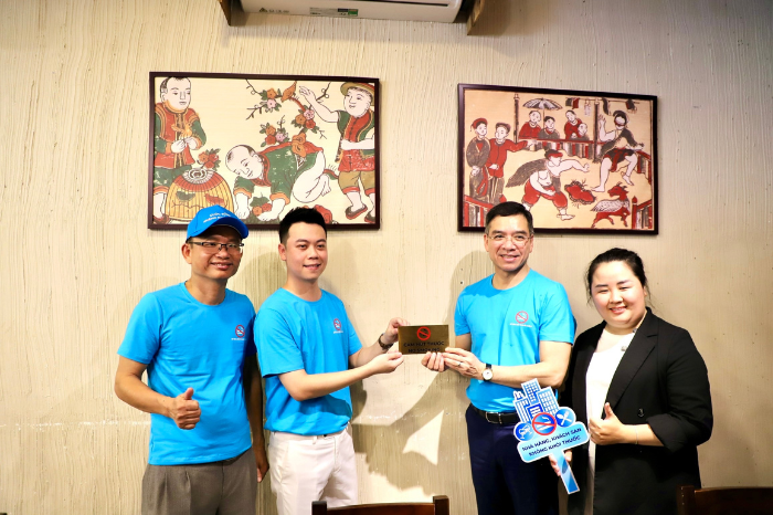 Các đại biểu thực hiện treo, dán biển cấm hút thuốc tại nhà hàng trên địa bàn TP Huế.