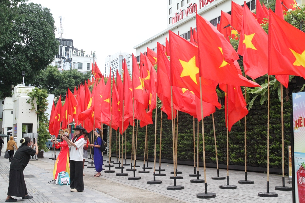 Người dân vui vẻ chụp hình tại Khu vực đường Phạm Ngọc Thạch, phường Sài Gòn rực rỡ mầu cờ Tổ quốc - Ảnh: VGP.