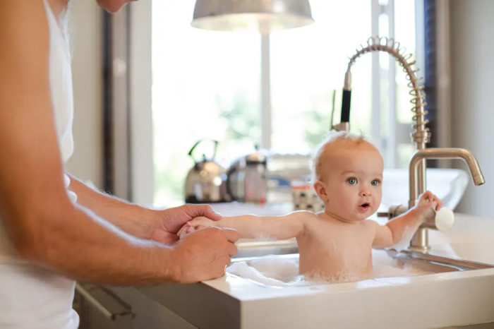 Để đảm bảo an toàn và vệ sinh, cha mẹ nên sử dụng chậu tắm chuyên dụng cho trẻ, thay vì tắm bé trong chậu rửa bát.