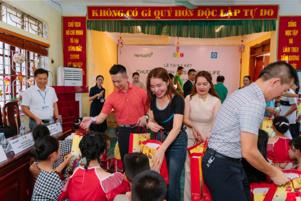 Các đại diện thuộc Herbalife Việt Nam trao quà cho các em nhỏ có hoàn cảnh khó khăn.