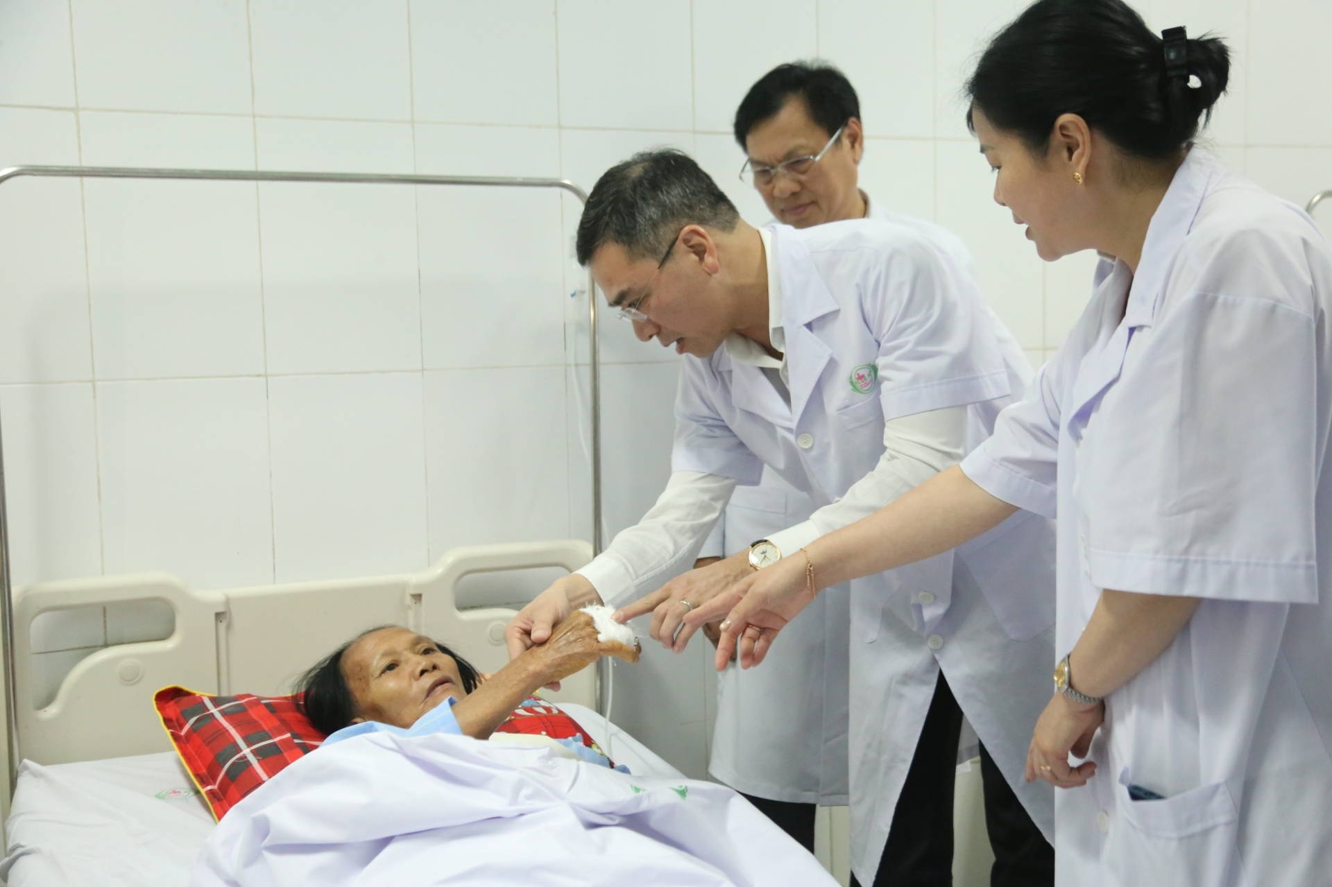 TS BS Hà Anh Đức thăm hỏi người nhà bệnh nhi bị thương trong vụ tấn công ở Bệnh viện Sản Nhi Nghệ An - Ảnh: Lê Hảo