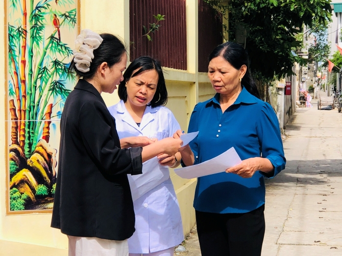 Cán bộ Trạm Y tế xã Tiến Thắng phát tờ rơi tuyên truyền phòng chống sốt xuất huyết tại cộng đồng - Ảnh: CDC Hà Nội