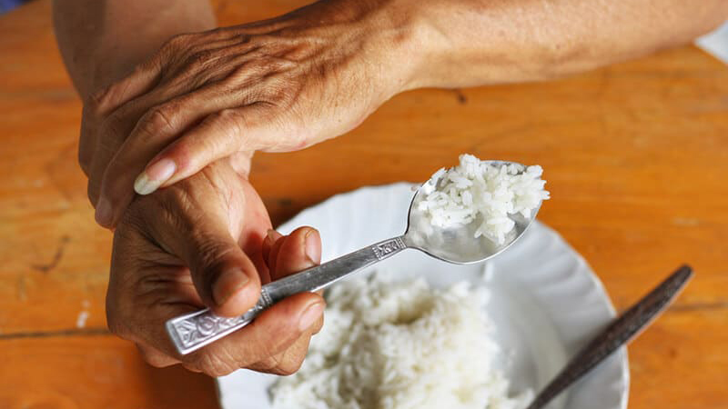 Triệu chứng Parkinson có thể cản trở hoạt động hàng ngày như cầm nắm, nhai và nuốt thức ăn