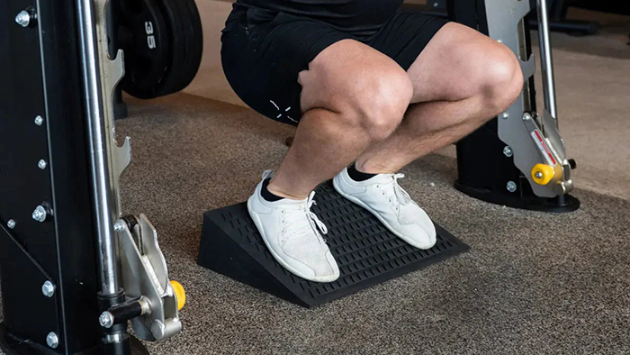 Biến thể squat kê gót, giúp dồn lực nhiều hơn vào cơ đùi trước và giảm áp lực lên lưng 