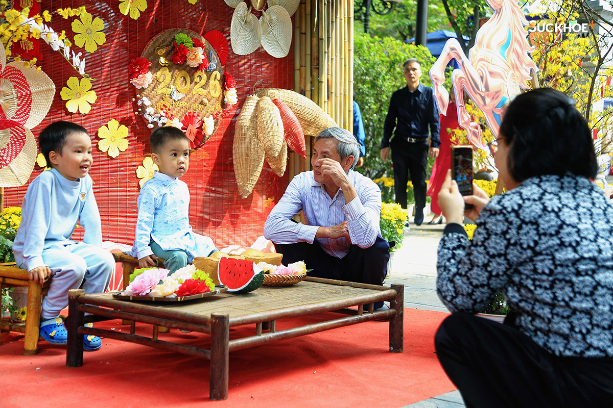 Một gia đình đang lưu lại hình ảnh của 2 thành viên nhí trong gia đình tại không gian Tết Bính Ngọ ở chùa Hà sáng mùng 1.