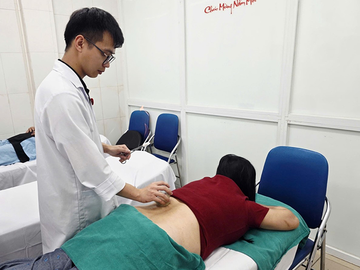 Bác sĩ sử dụng phương pháp giác hơi để điều trị cho bệnh nhân đau lưng - Ảnh: BVCC