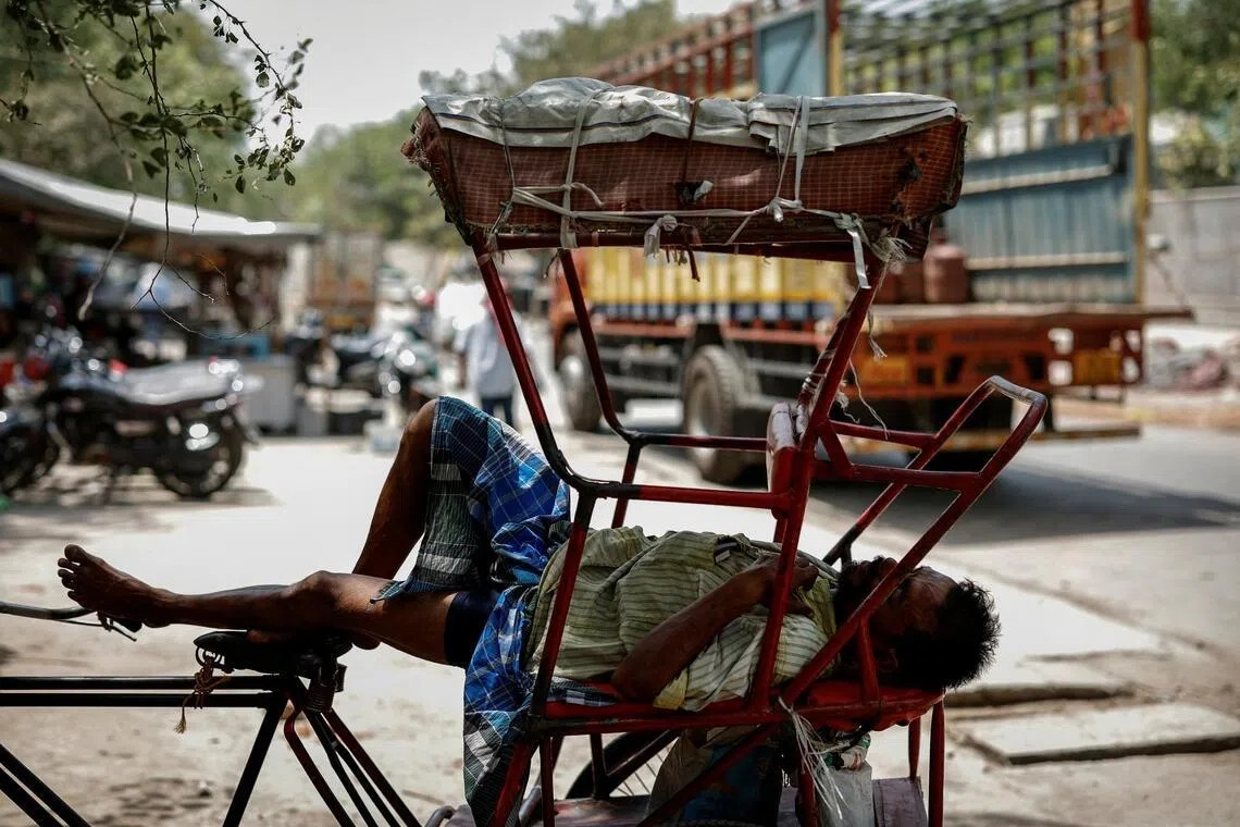 Một người đàn ông ngủ trong xe kéo của mình trong đợt nắng nóng vào một ngày Hè nóng nực ở New Delhi, Ấn Độ - Ảnh: Reuters