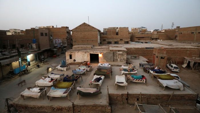 Trong những đợt nắng nóng, nam giới ở Jacobabad, Pakistan ngủ trên sân thượng để đón gió mát - Ảnh: Reuters
