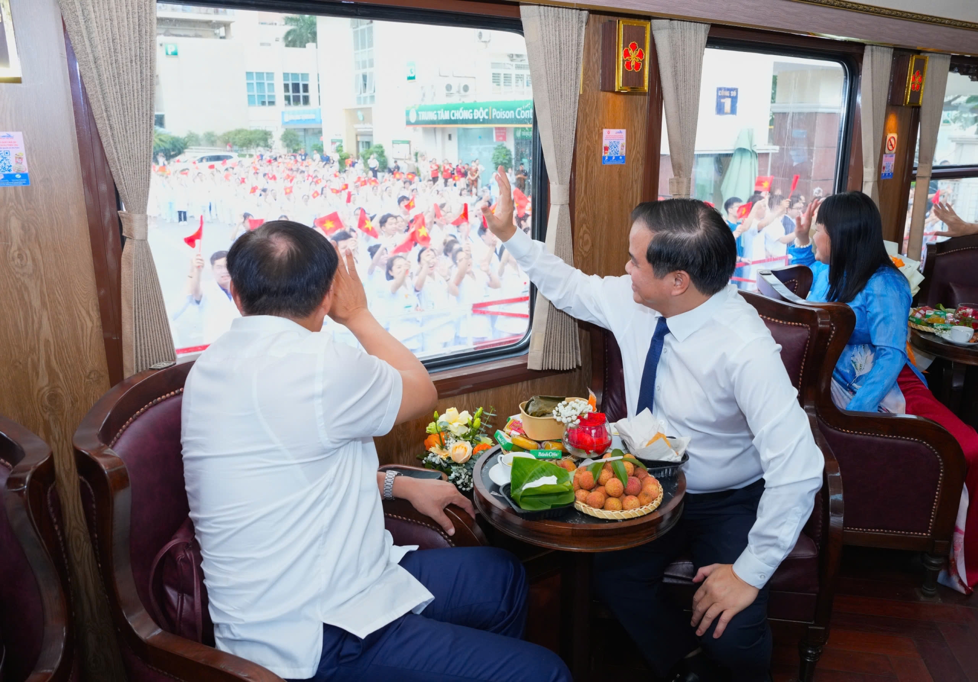 Các đại biểu trên Đoàn tàu Bạch Mai vẫy tay chào các y bác sĩ khi tàu đi qua Bệnh viện Bạch Mai cơ sở Hà Nội - Ảnh: Thế Anh/Sức Khỏe+