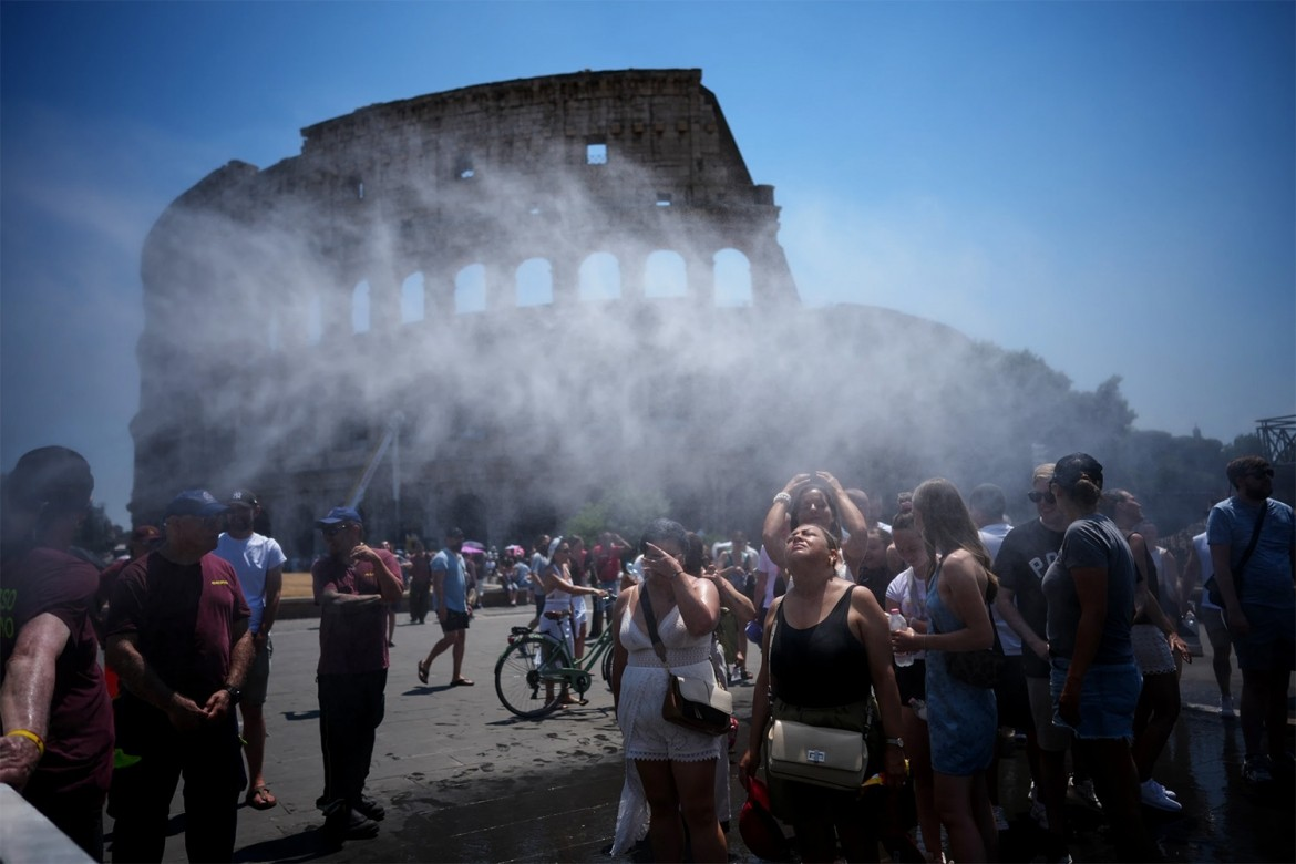 Người dân tìm cách giải nhiệt trước vòi phun nước do chính quyền thành phố Rome (Italy) bố trí để giúp du khách tham quan Đầu trường La Mã bớt nóng bức khi nhiệt độ đạt mức kỷ lục - Ảnh: AP