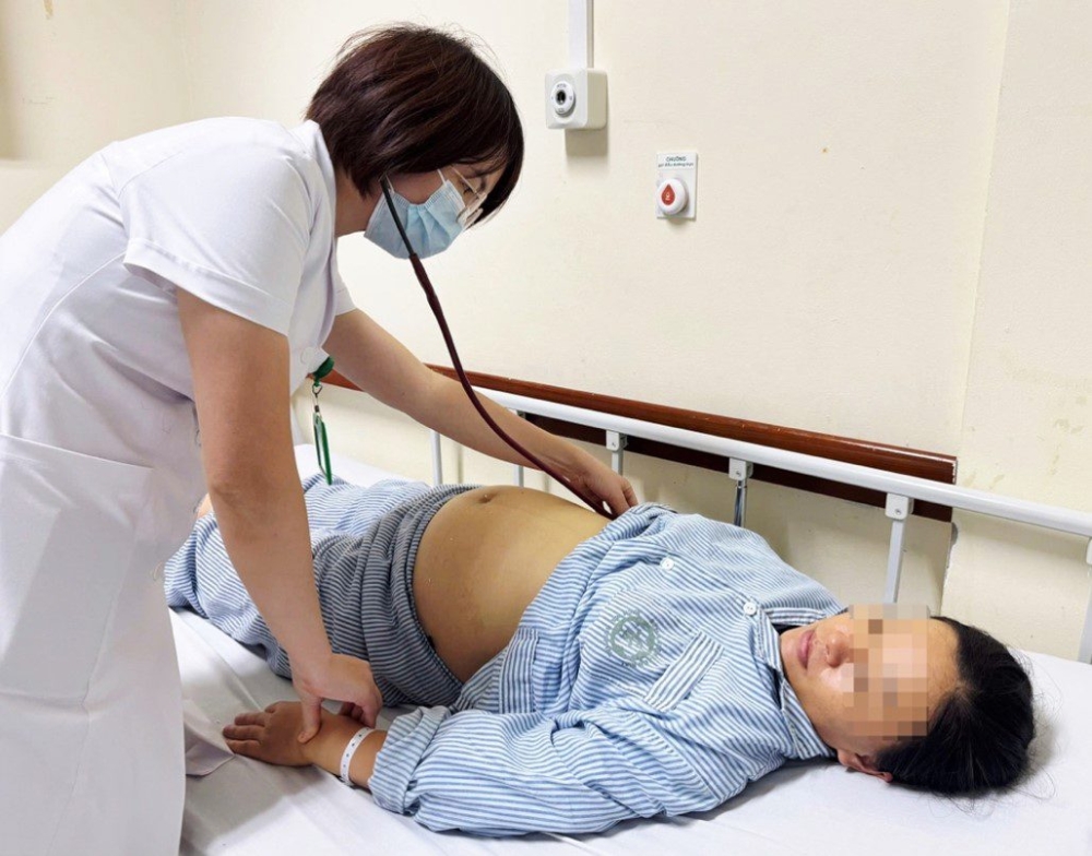 Bác sĩ Viện Y học nhiệt đới Bạch Mai thăm khám cho sản phụ bị viêm gan B đang điều trị - Ảnh: BVCC
