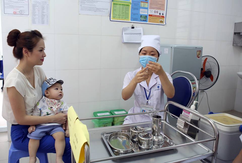 Con trai MC Đan Lê quan sát chăm chú khi điều dưỡng lấy vaccine...