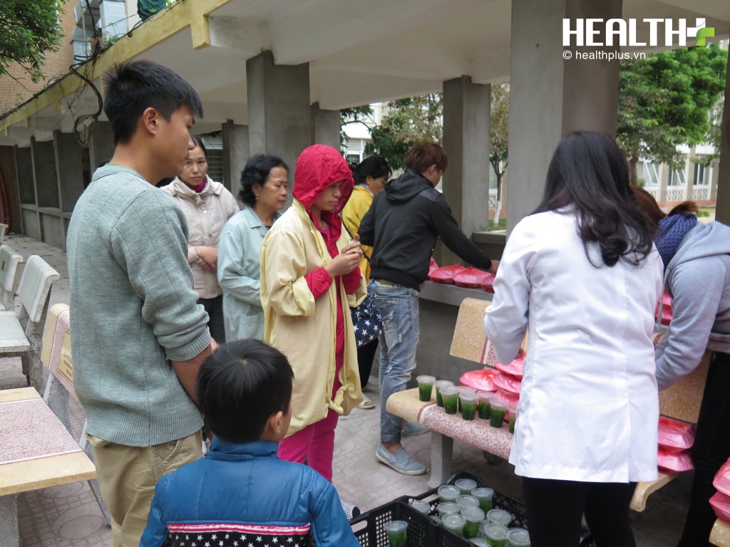 Bệnh nhân hoặc người thân xếp hàng lần lượt để nhận cơm từ thiện.