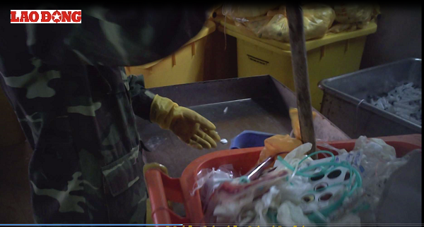 Một nhân viên đang thu gom rác thải y tế bằng nhựa từ các thùng rác của bệnh viện. 