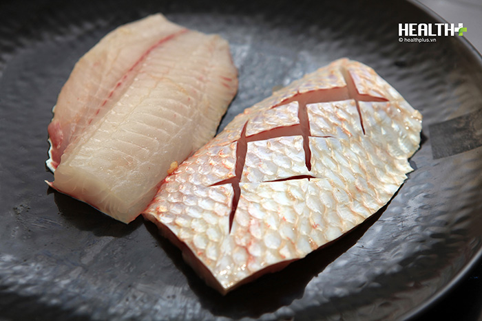Bước 1: Cá diêu hồng làm sạch vẩy sau đó lọc bỏ xương chia thành bốn phần, các phần dùng dao khía hình quả trám phần da cá, sau đó tẩm ướp với muối và tiêu trắng.